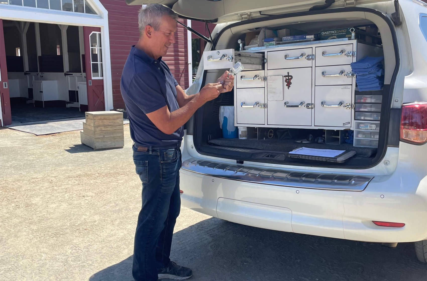 Veterinarian standing next to van with medical veterinarian equipment