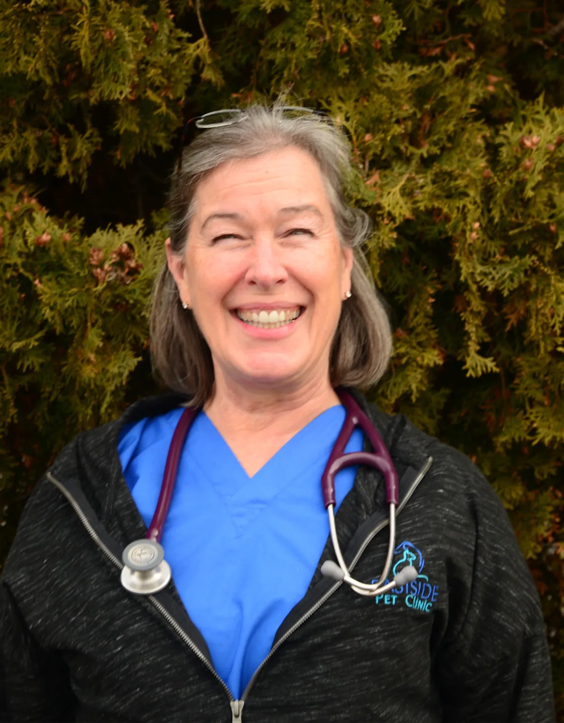 Dr. Grisham sitting with a dog in front of the Eastside sign Dr. Grisham sitting with a dog in front of the Eastside sign