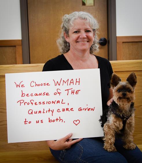 Client holding sign that support West Mountain Animal Hospital