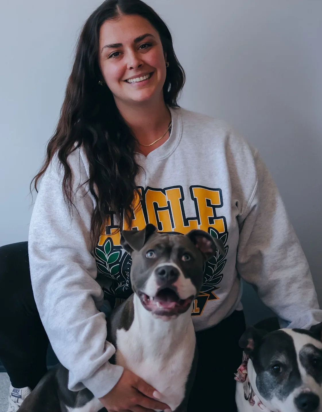A hospital manager posing with a dog A hospital manager posing with a dog