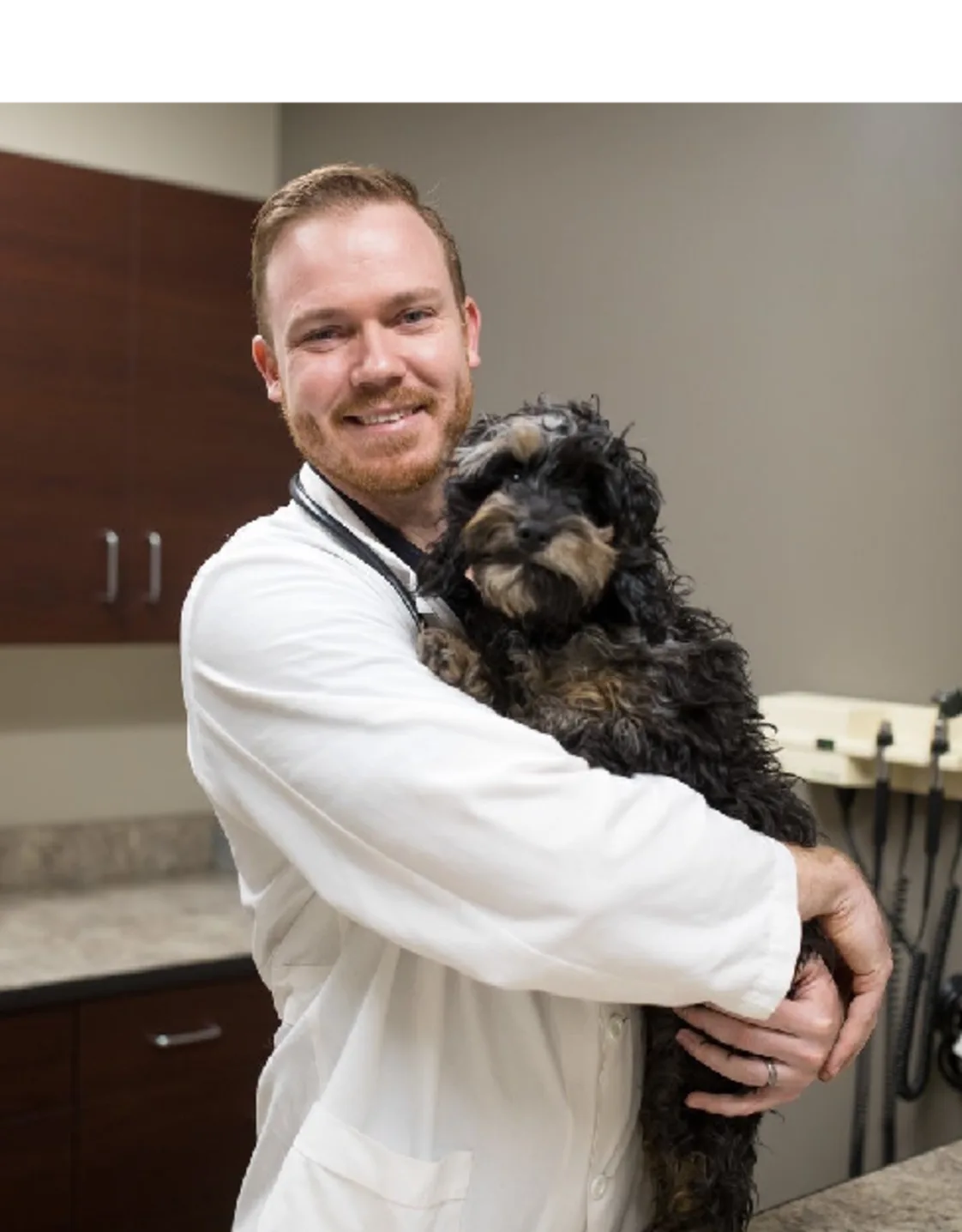 A veterinarian posing with a black dog A veterinarian posing with a black dog