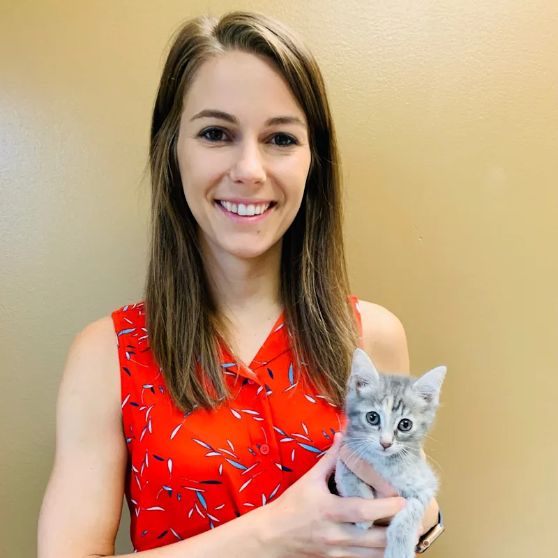 Dr. Ashley Flautt smiling at the camera while holding a cat Dr. Ashley Flautt smiling at the camera while holding a cat