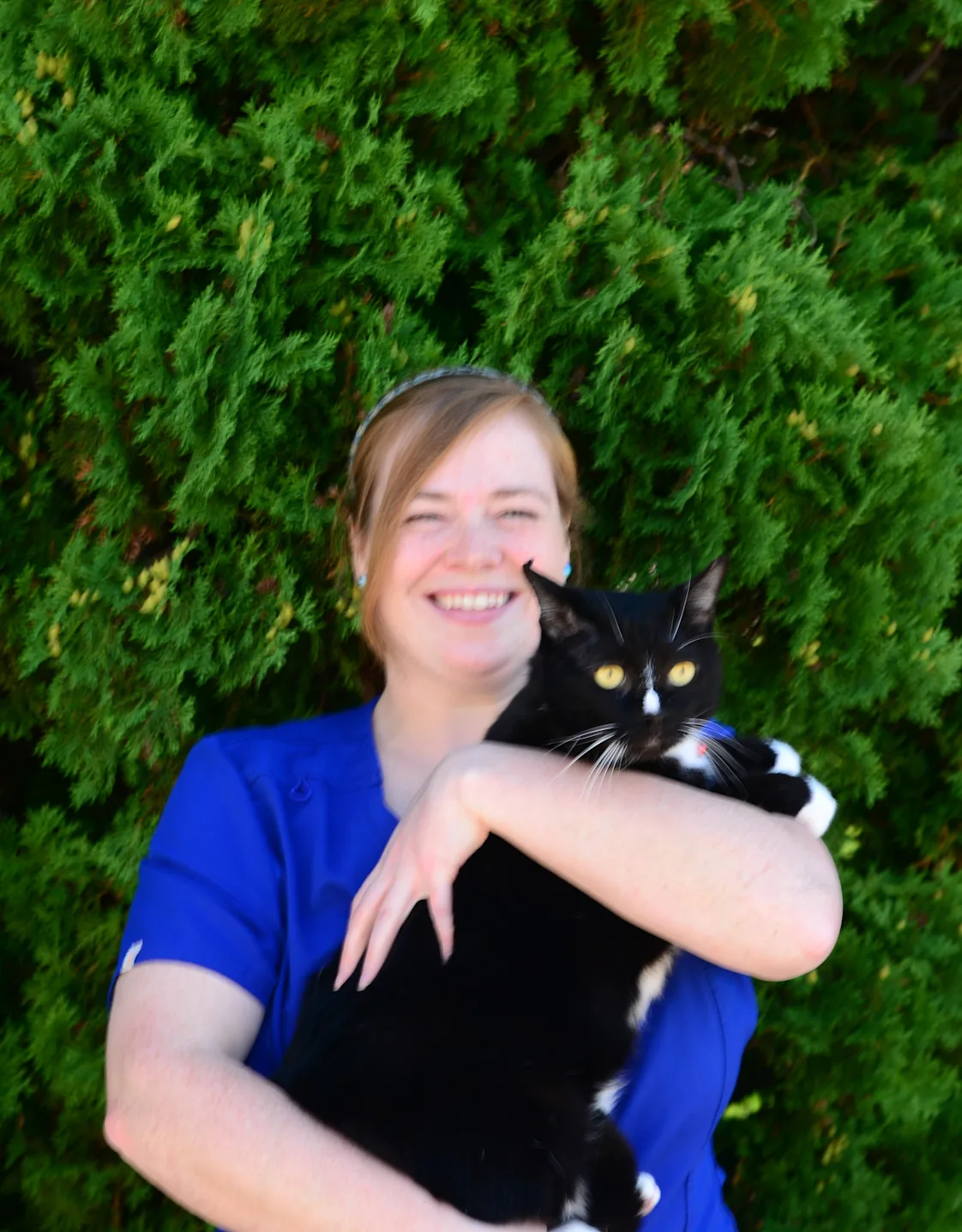 Kira hugging a cat in front of the Eastside sign Kira hugging a cat in front of the Eastside sign