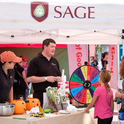 Two Staff Members Providing Information at SAGE Booth