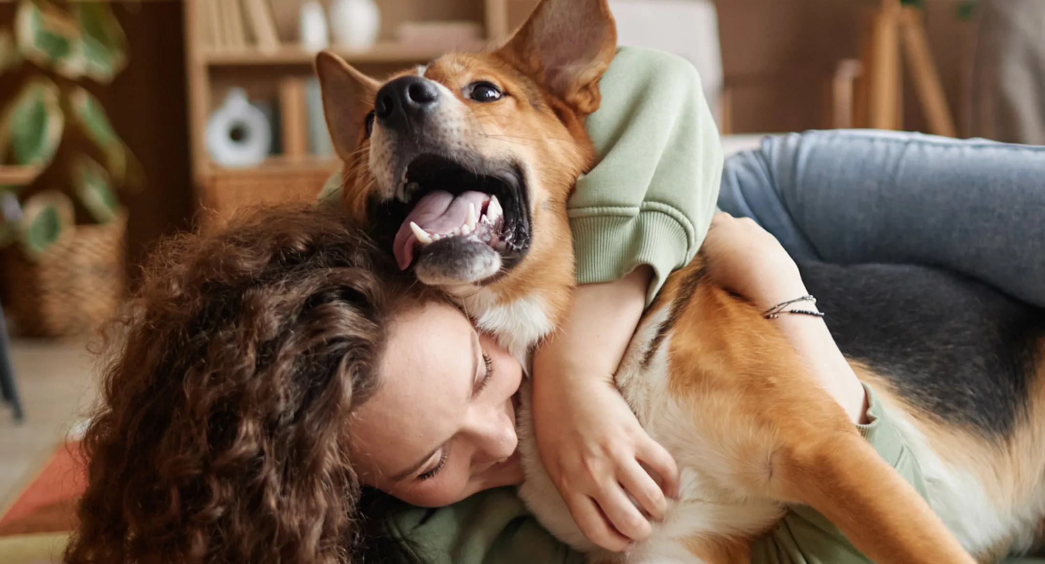 Woman laying on the floor with her arms wrapped around and cuddling a dog. Woman laying on the floor with her arms wrapped around and cuddling a dog.