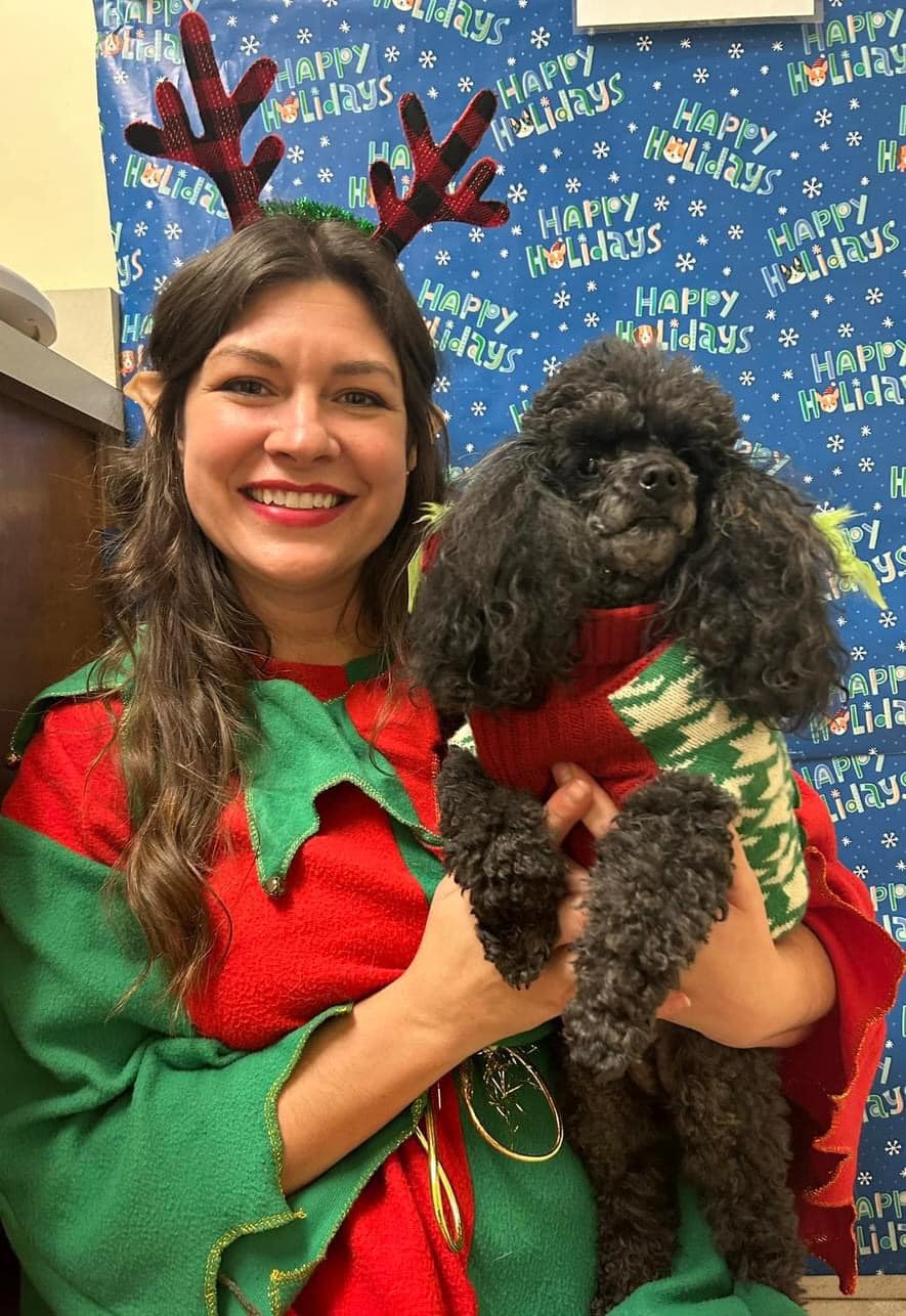 Staff member with pet posing in Christmas outfits