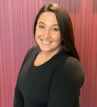 Caitlin wearing a long-sleeve black shirt and smiling. Caitlin wearing a long-sleeve black shirt and smiling.