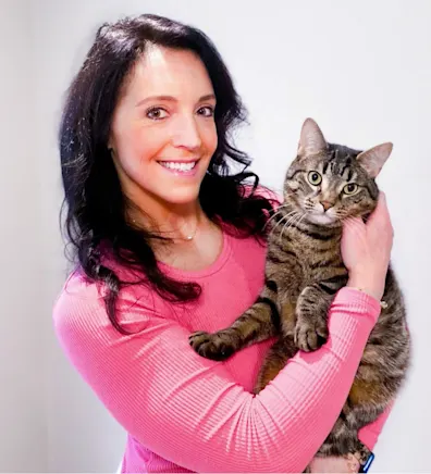Dr. Mercedes Carota smiling holding a striped cat Dr. Mercedes Carota smiling holding a striped cat