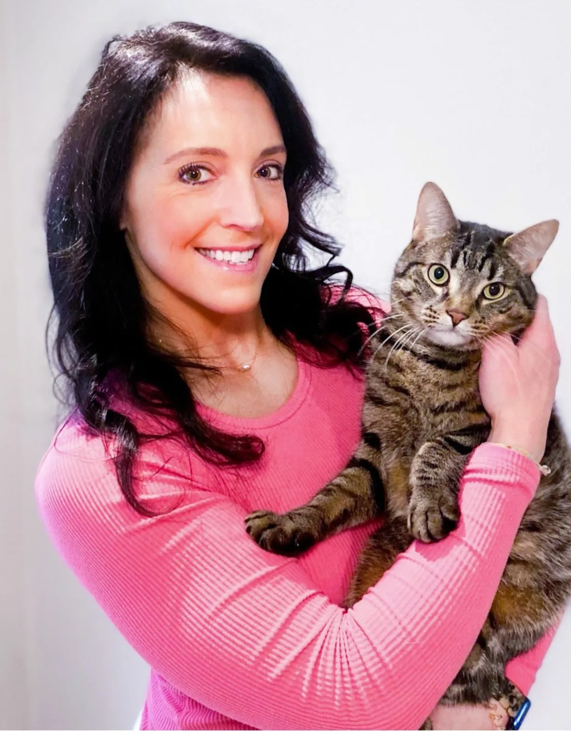 Dr. Mercedes Carota smiling holding a striped cat Dr. Mercedes Carota smiling holding a striped cat