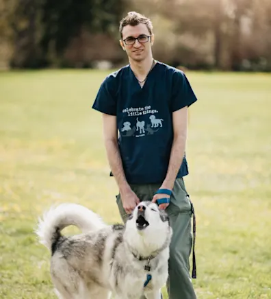 Weston Scott standing with a husky on a leash Weston Scott standing with a husky on a leash