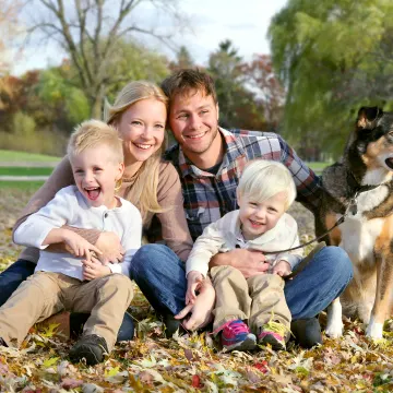 dog sitting with family in leaves