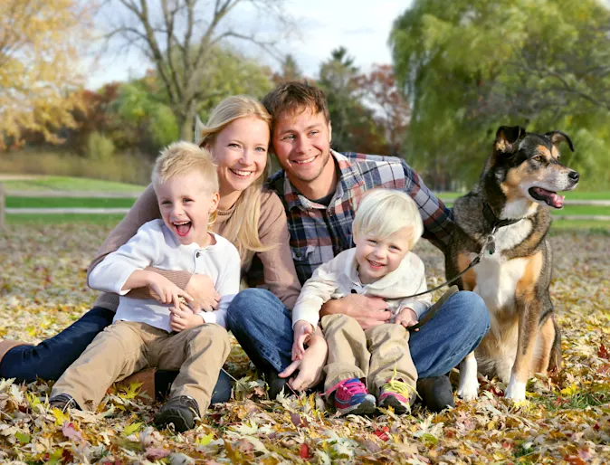 dog sitting with family in leaves