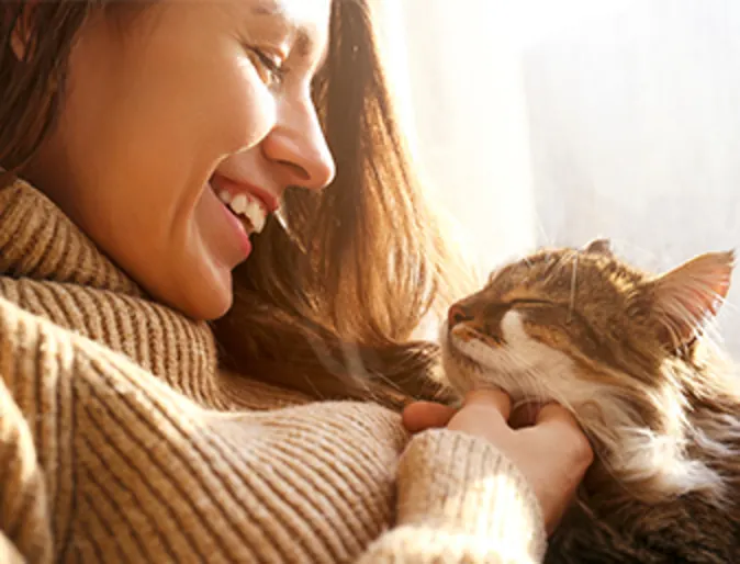 Woman scratching cat's chin