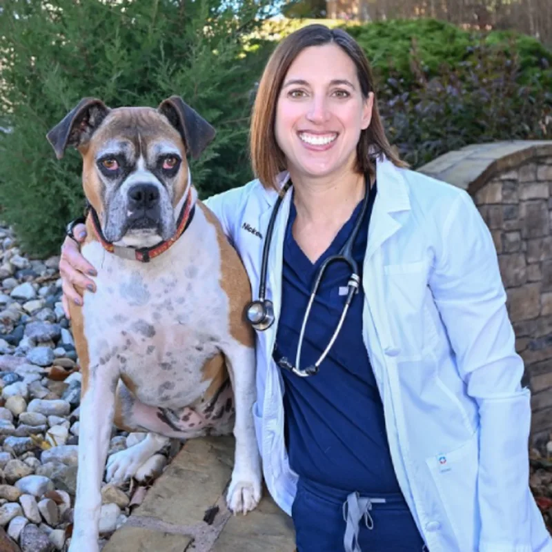 A veterinarian posing with a dog A veterinarian posing with a dog