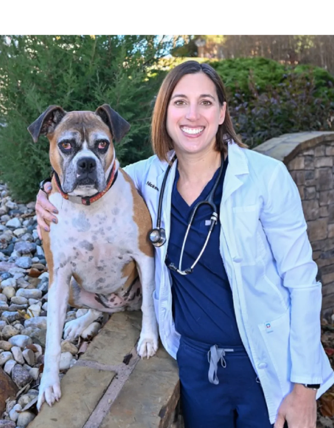 A veterinarian posing with a dog A veterinarian posing with a dog