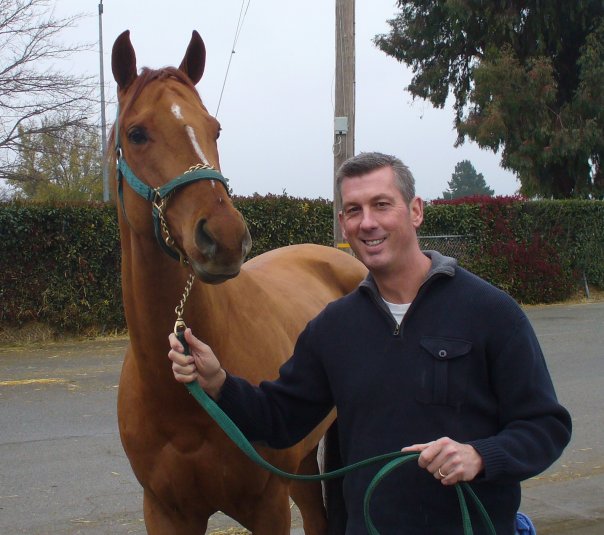 Dr. Browning holding the bridle of an athletic brown horse
