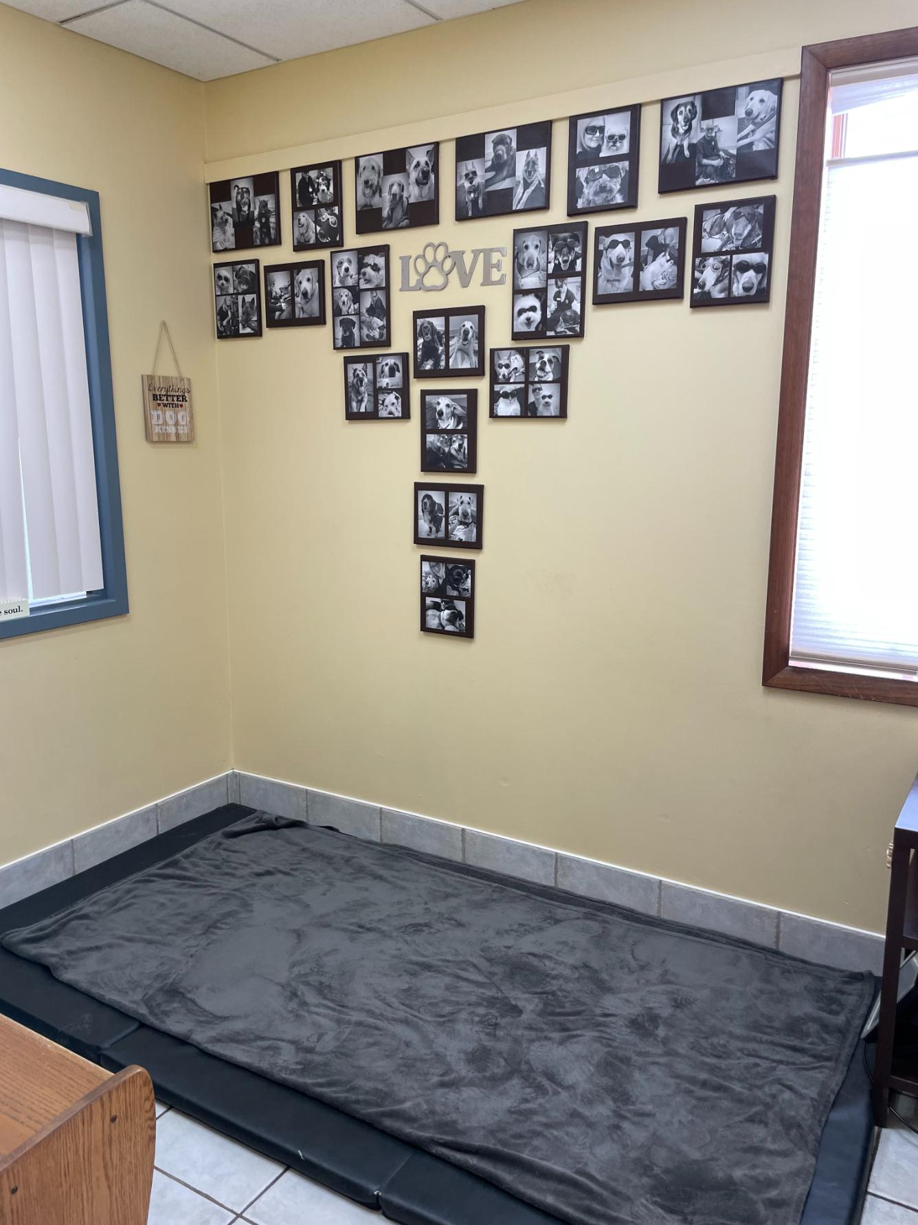 Corner of room with blanket on floor and black & white images hung