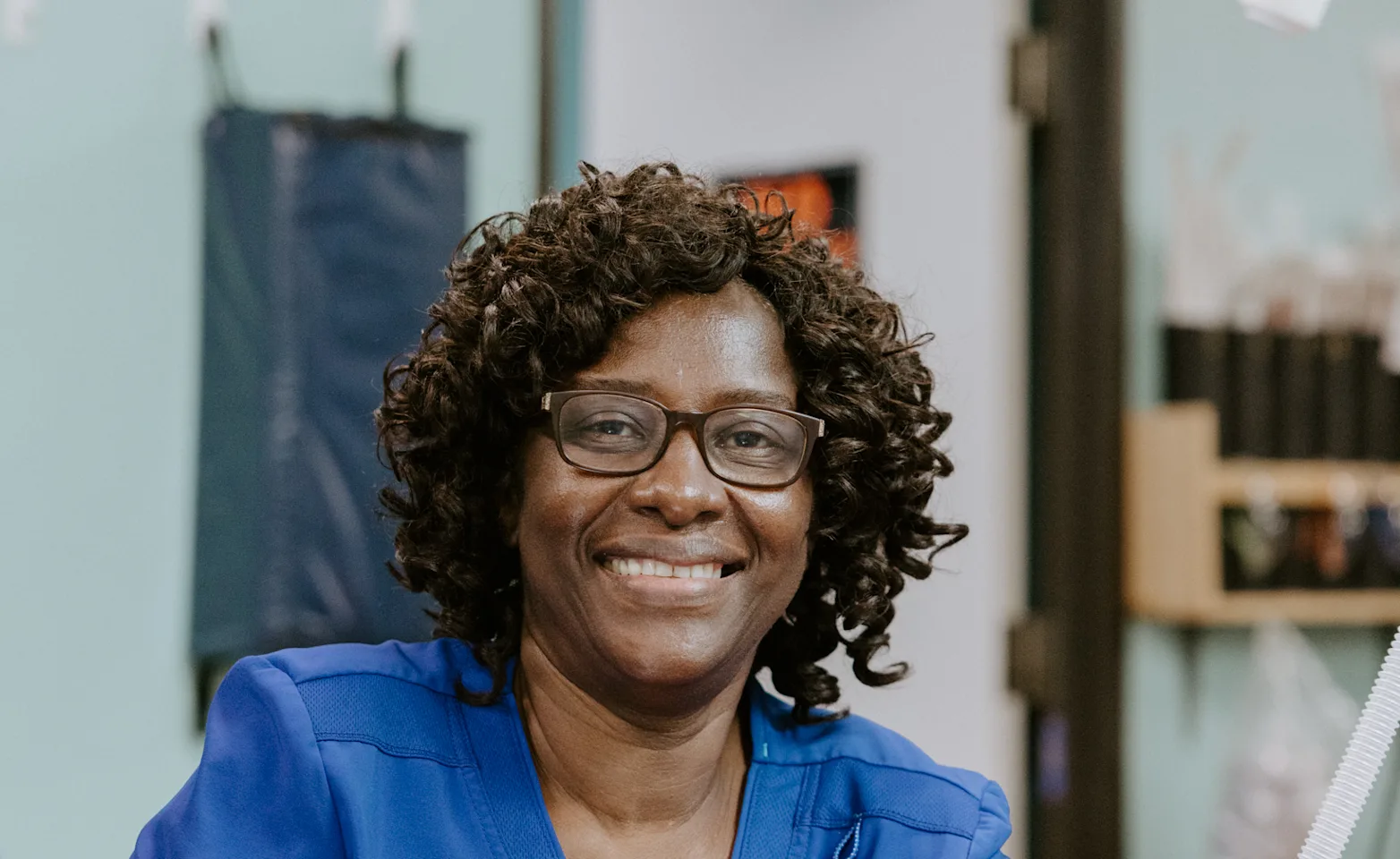 A smiling veterinary caregiver in a treatment room A smiling veterinary caregiver in a treatment room