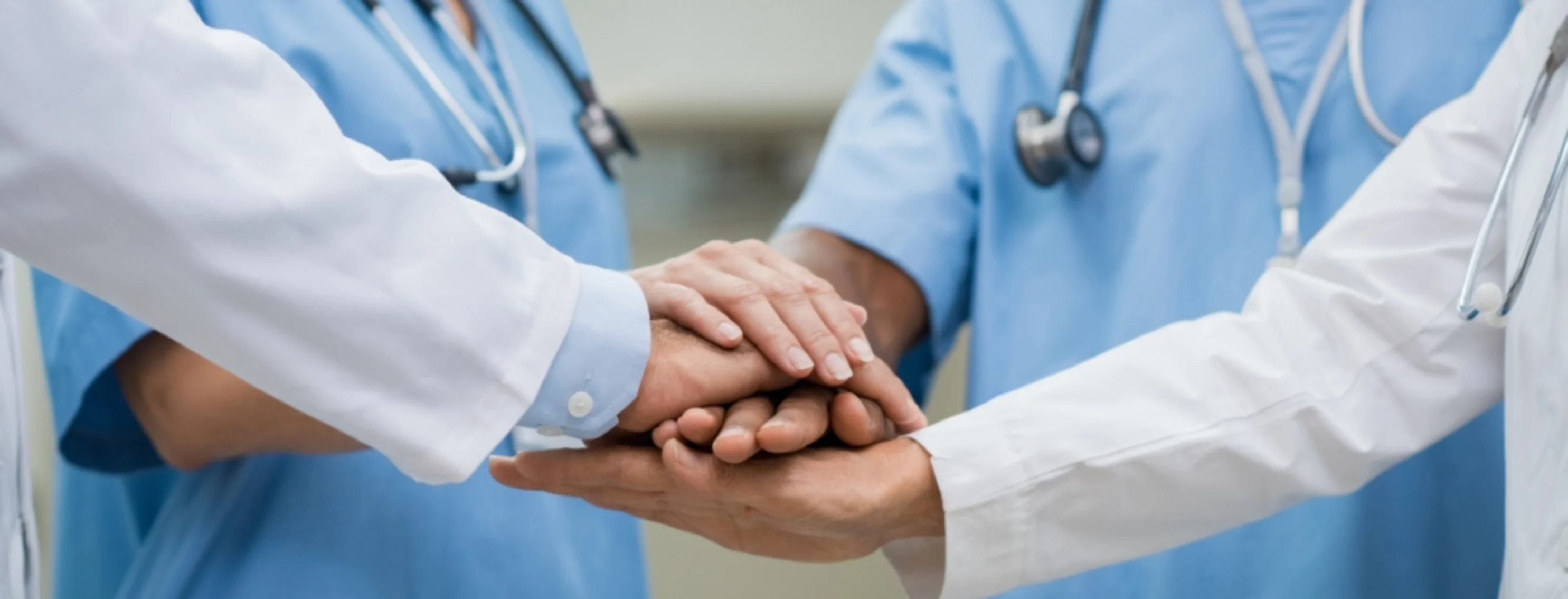 Medical staff touching hands.