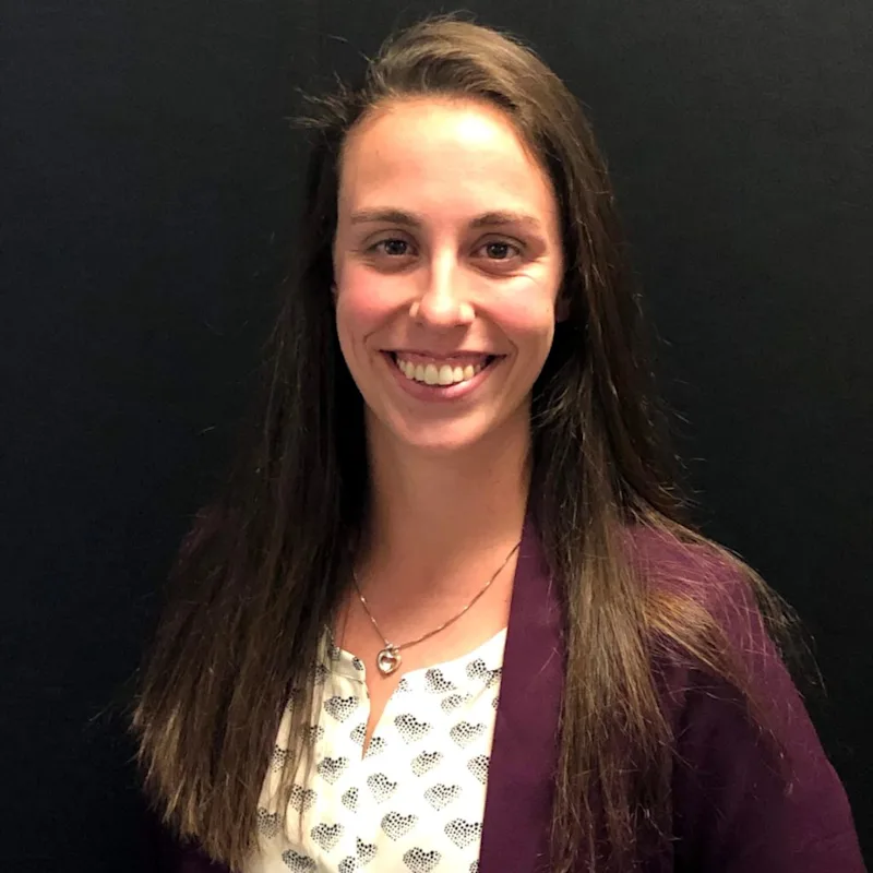 Dr. Adrienne Greenwood standing in front of a wall Dr. Adrienne Greenwood standing in front of a wall