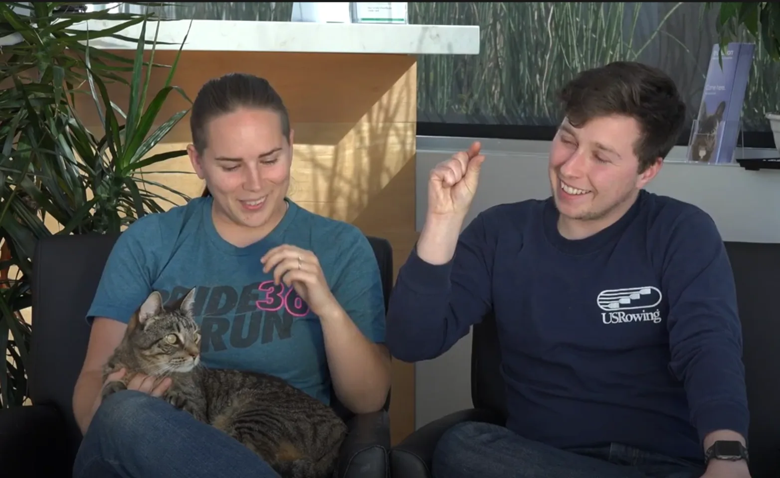 Two people sitting down with a cat