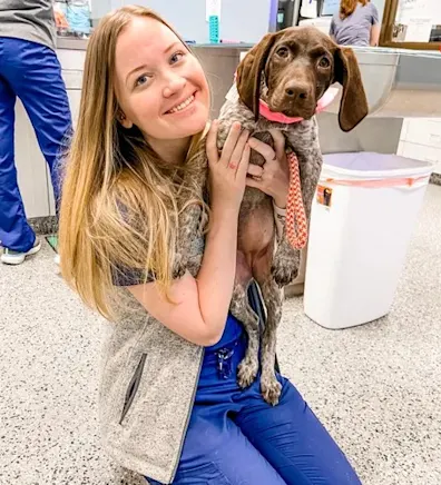 Heather Suhr smiling holding a small fluffy white dog Heather Suhr smiling holding a small fluffy white dog