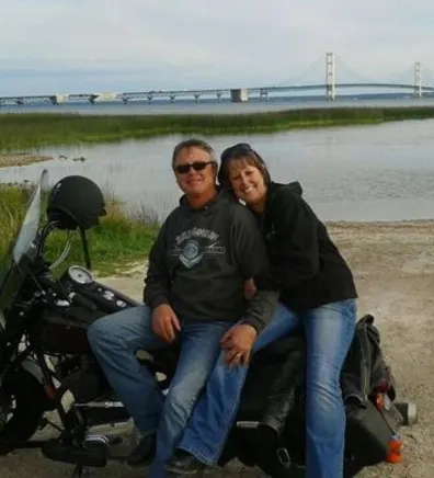 Lisa and her husband sitting on a motorcycle