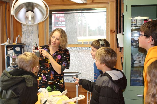 A member of staff at All Creatures Veterinary Clinic showing some children how a heartrate monitor works