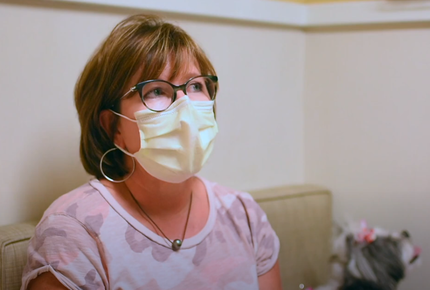Woman with mask and her dog giving a testimonial
