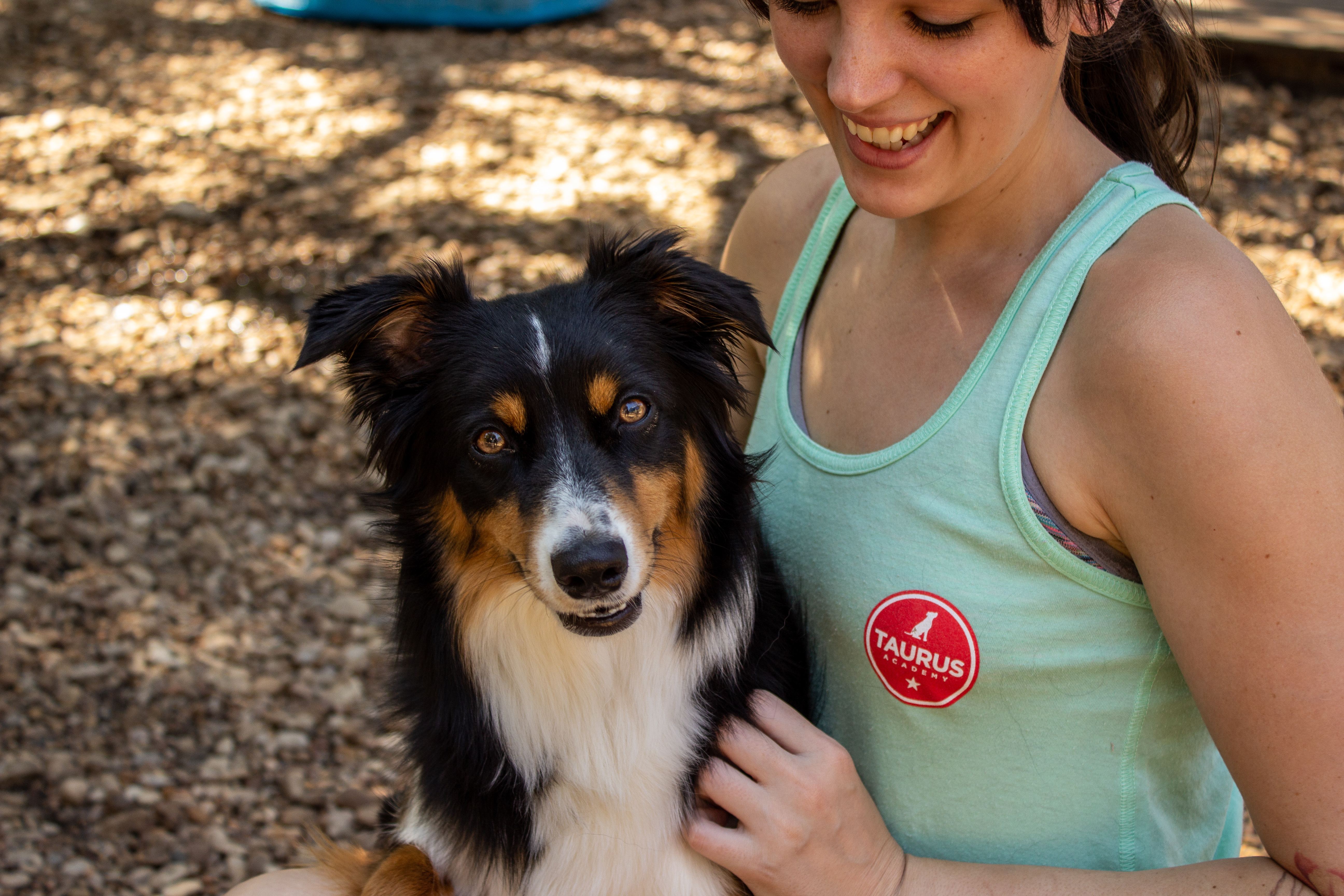 a woman holds a dog and smiles