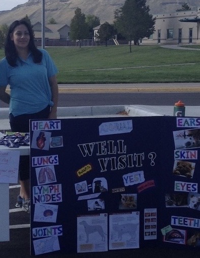 Team member standing in front of the Arvada flats veterinary hospital event table
