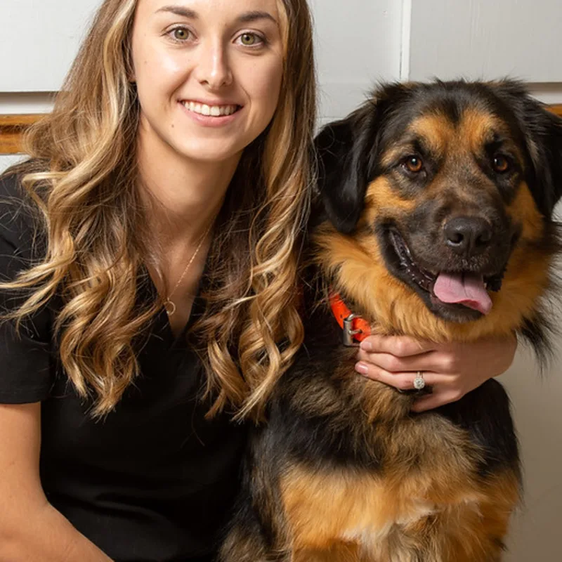 Krista smiling at the camera with a dog Krista smiling at the camera with a dog