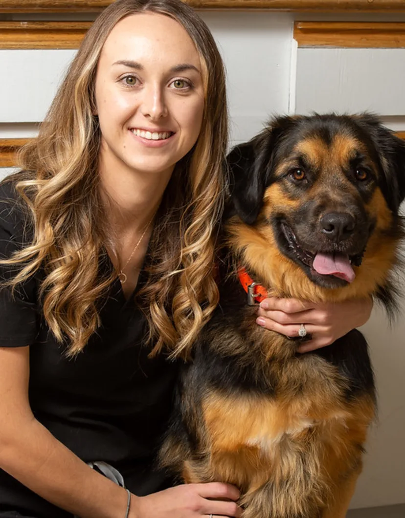 Krista smiling at the camera with a dog