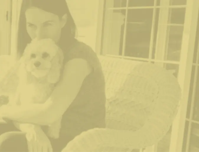 Woman and dog sitting in a chair with a yellow filter on photo