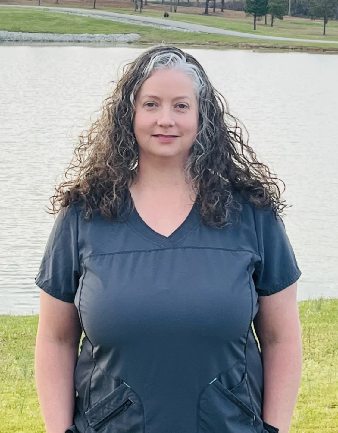 Andrea smiling standing in front of a pond Andrea smiling standing in front of a pond