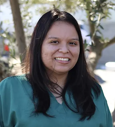 Woman with green scrubs smiling at the camera Woman with green scrubs smiling at the camera