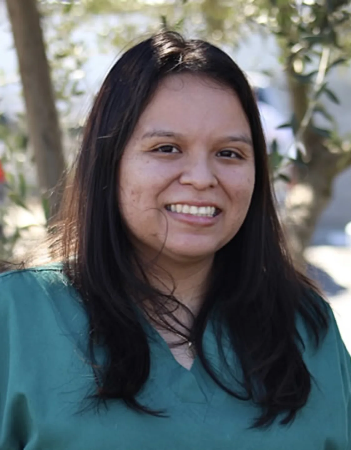 Woman with green scrubs smiling at the camera Woman with green scrubs smiling at the camera