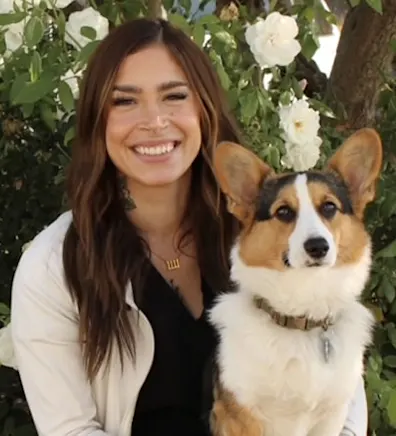 Woman staring at camera holding corgi Woman staring at camera holding corgi