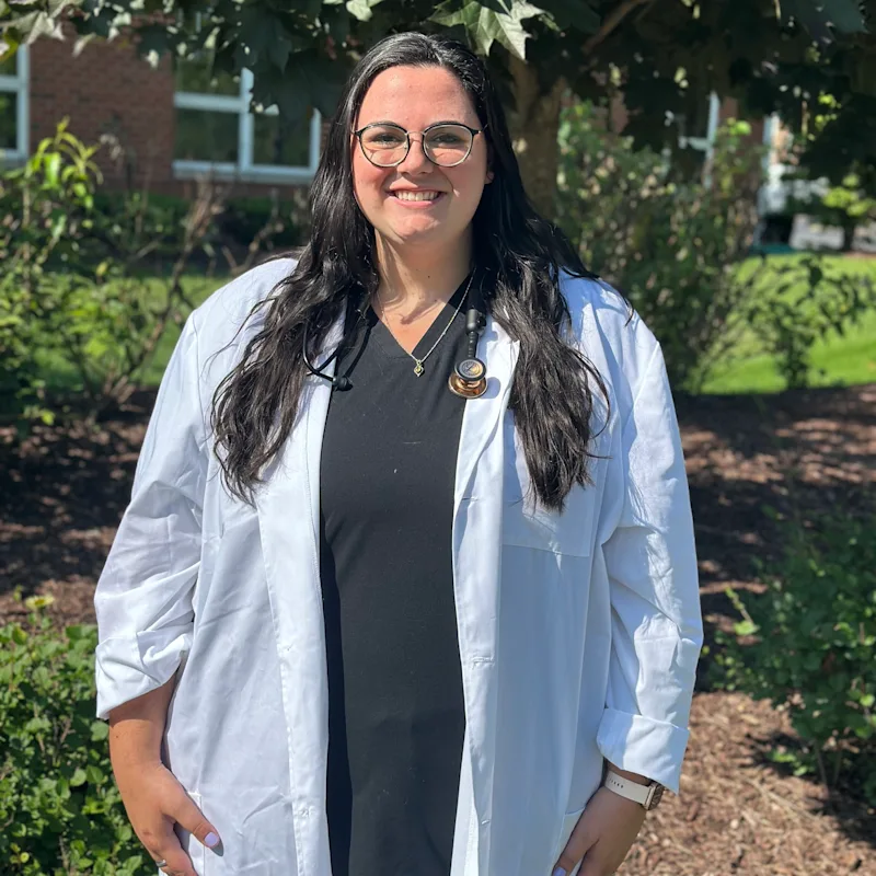 Dr. Lauren McKay standing outside wearing a white lab coat Dr. Lauren McKay standing outside wearing a white lab coat