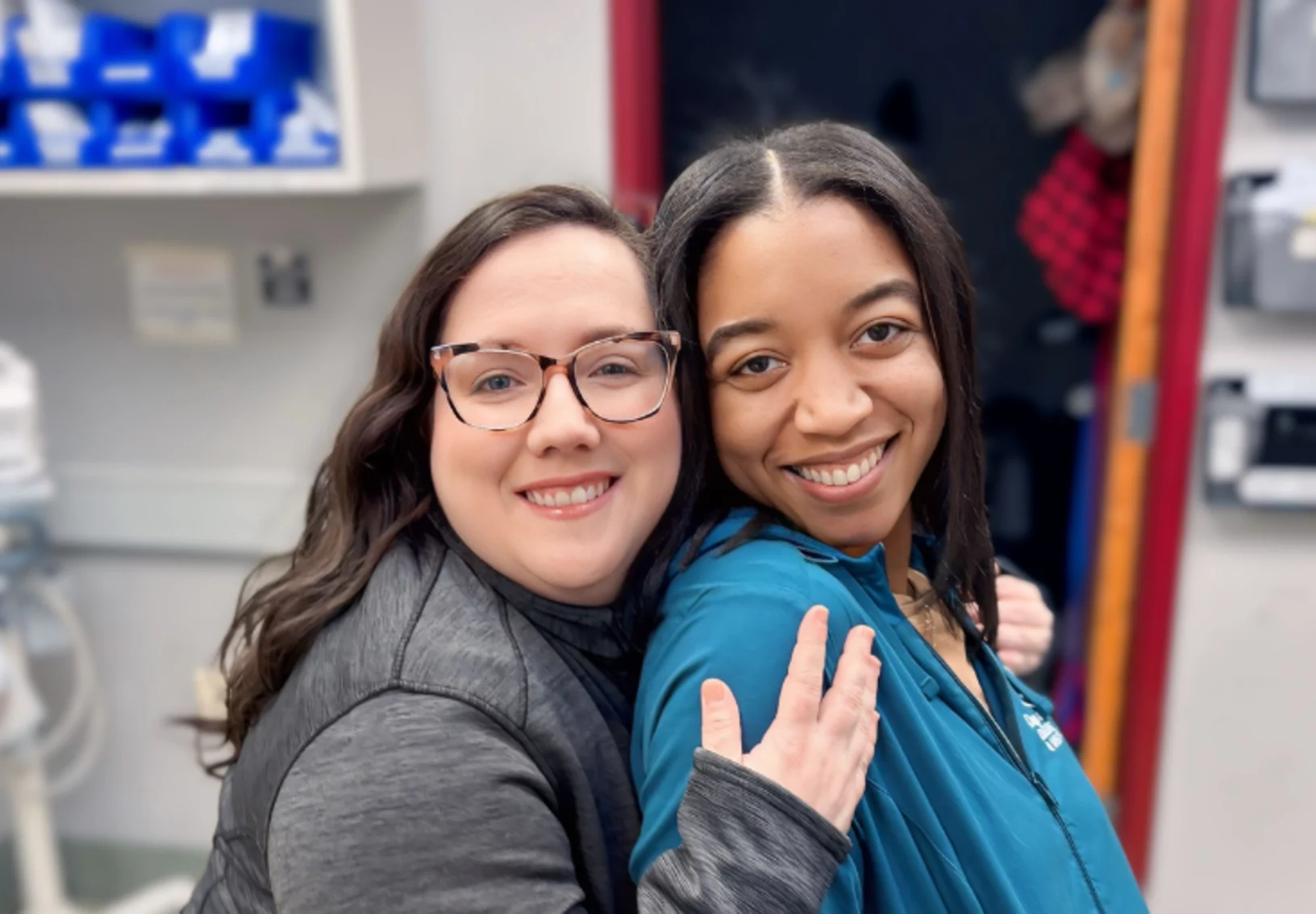Two staff members smiling and hugging Two staff members smiling and hugging