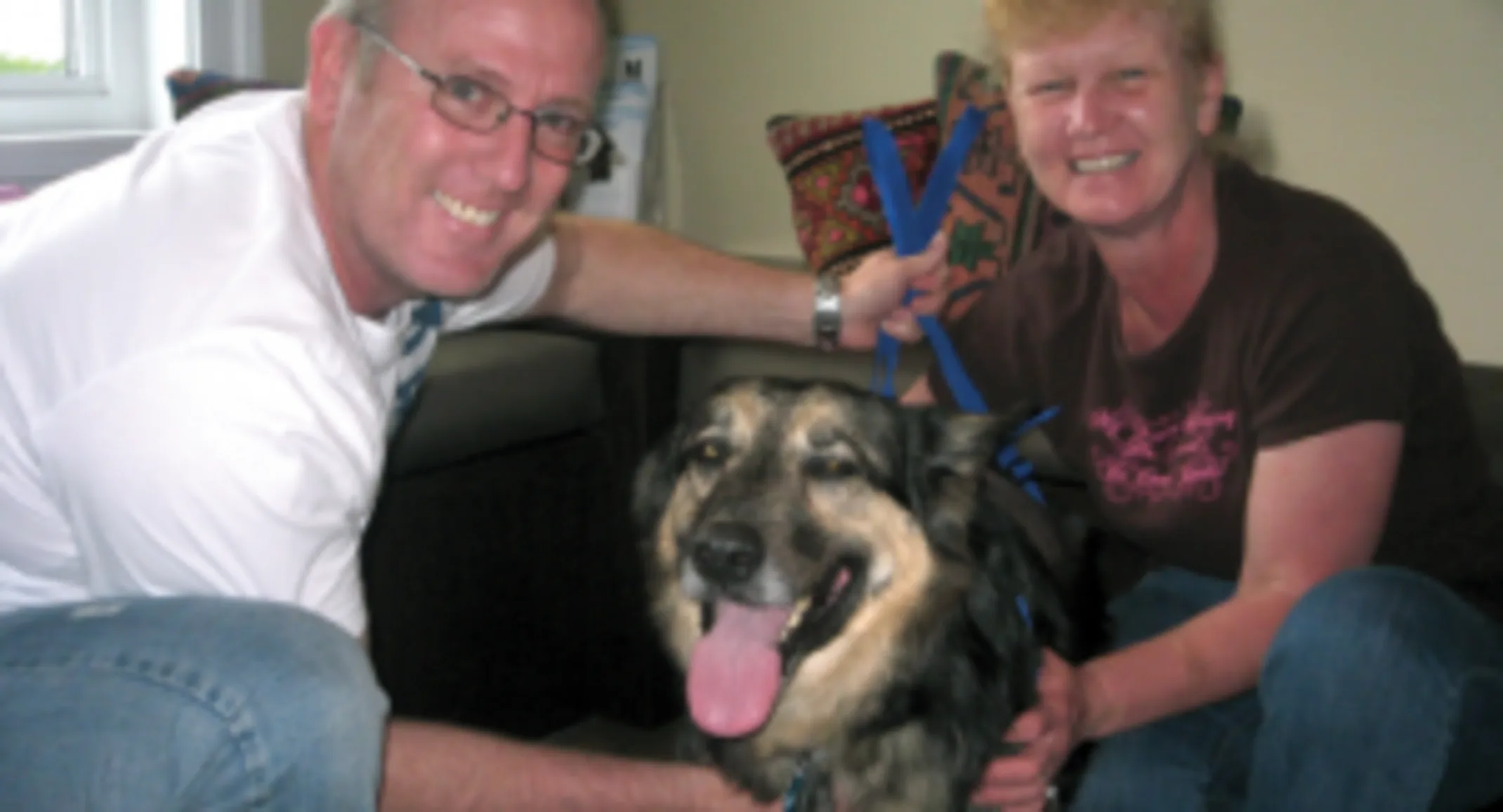 Two people smiling next to Prinz, a German Shepherd mix Two people smiling next to Prinz, a German Shepherd mix