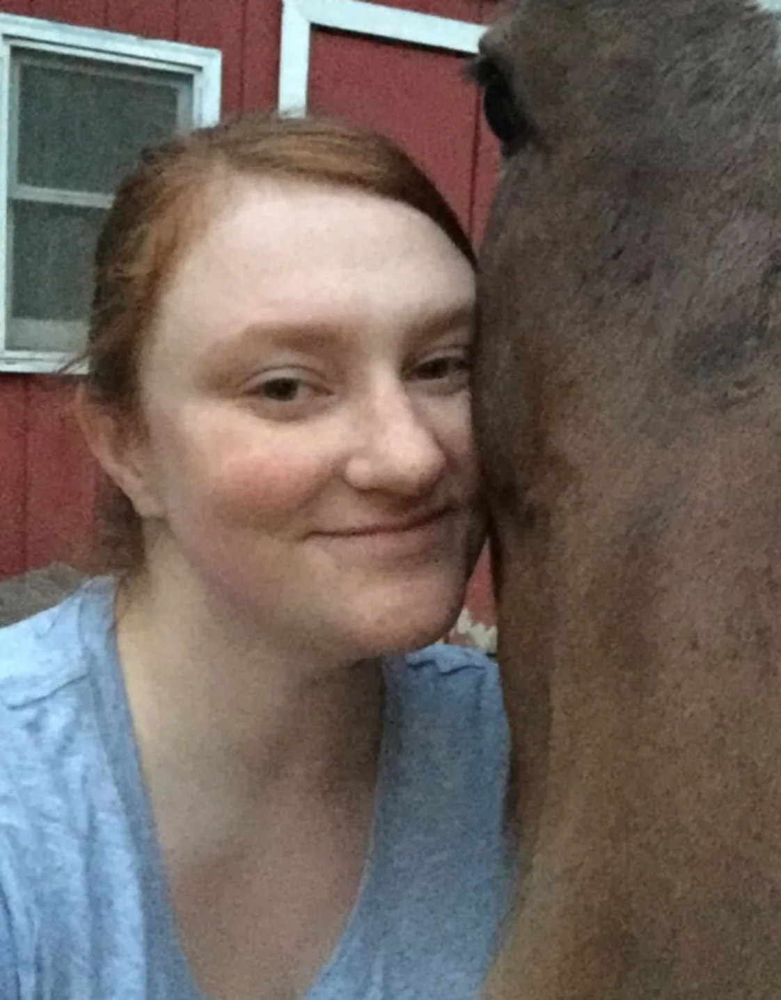 Kaycee leaned up against a brown horse's face Kaycee leaned up against a brown horse's face