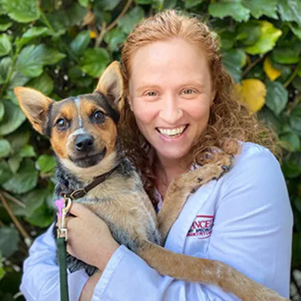 Nanelle Barash smiling holding a brown dog