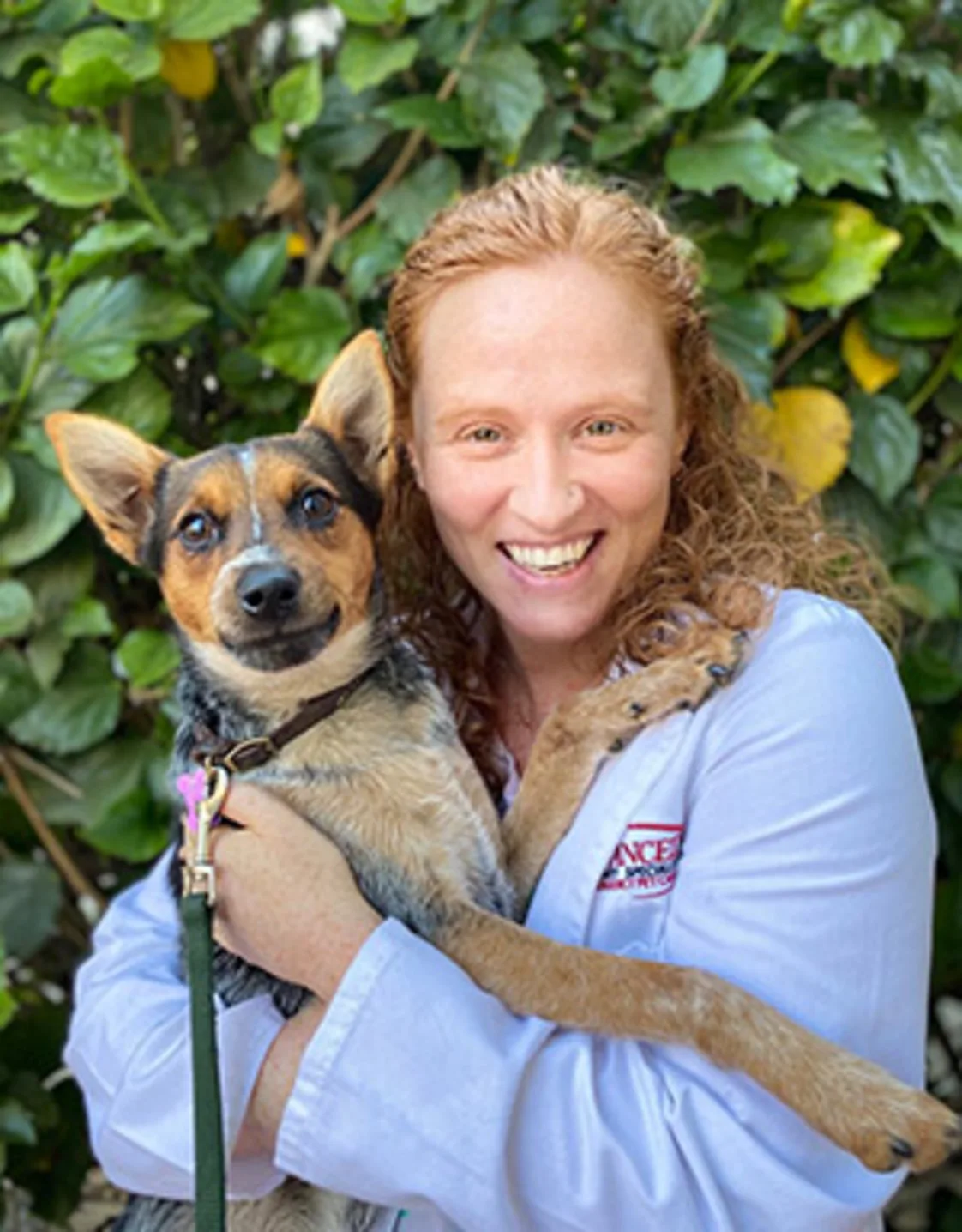 Nanelle Barash smiling holding a brown dog Nanelle Barash smiling holding a brown dog