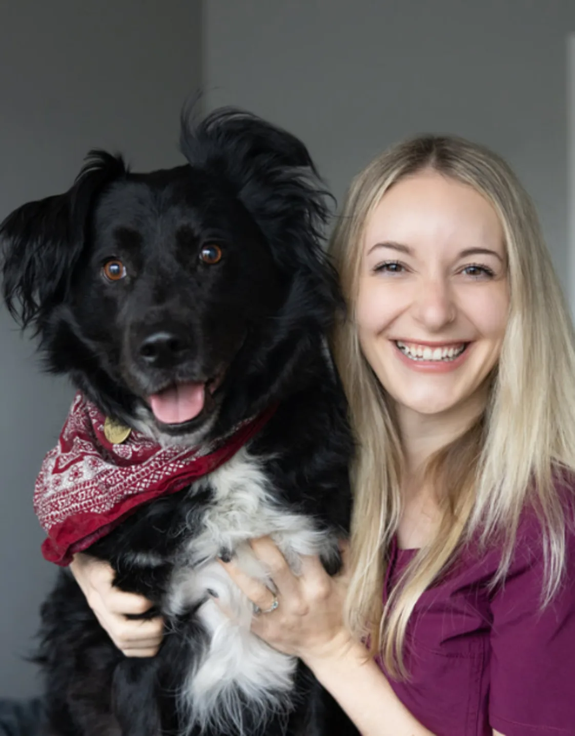 Hannah holding a black and white dog with a red bandana on Hannah holding a black and white dog with a red bandana on