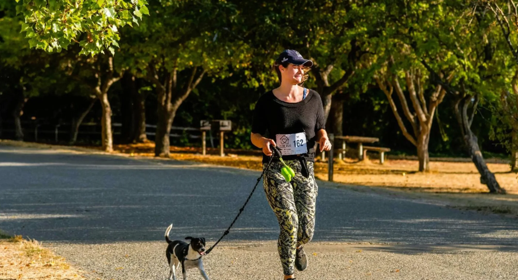 A photo of a woman walking her dog for canine fitness month A photo of a woman walking her dog for canine fitness month