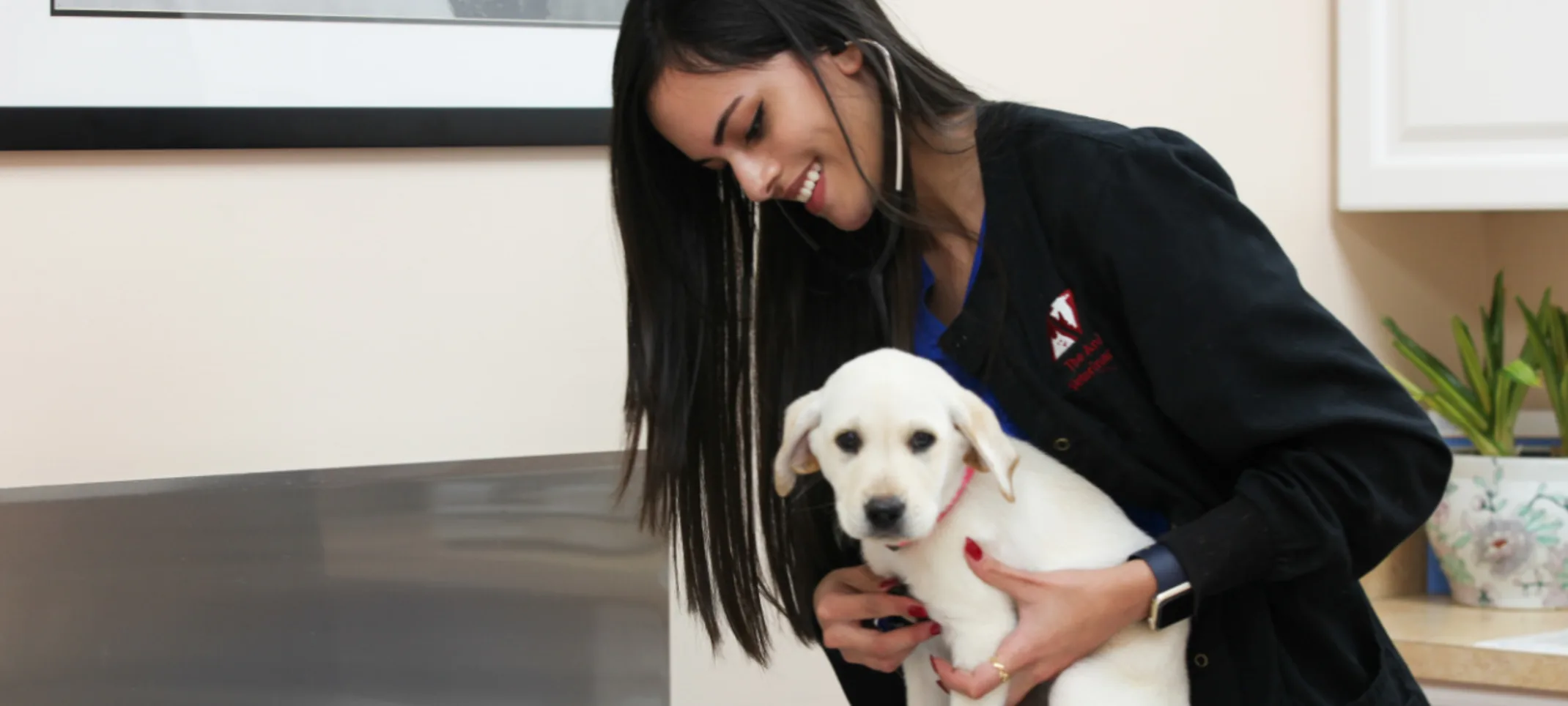 Staff member with a white puppy at The Animalife Veterinary Center Staff member with a white puppy at The Animalife Veterinary Center
