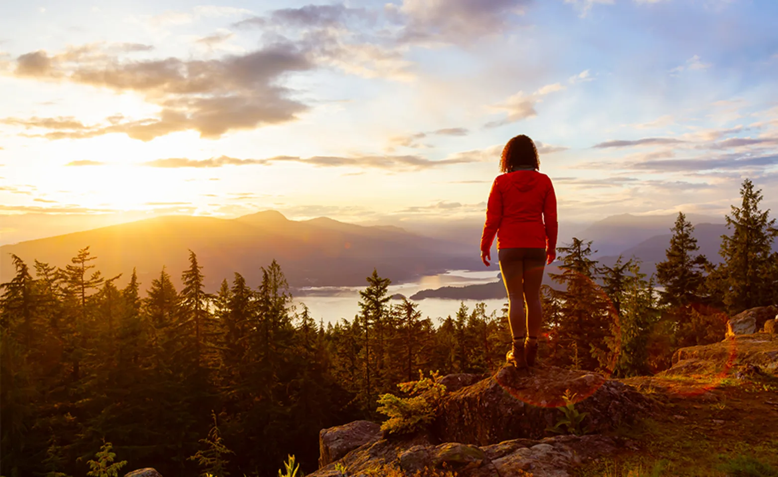 A person standing on top of a mountain on Bowen Island, BC. A person standing on top of a mountain on Bowen Island, BC.