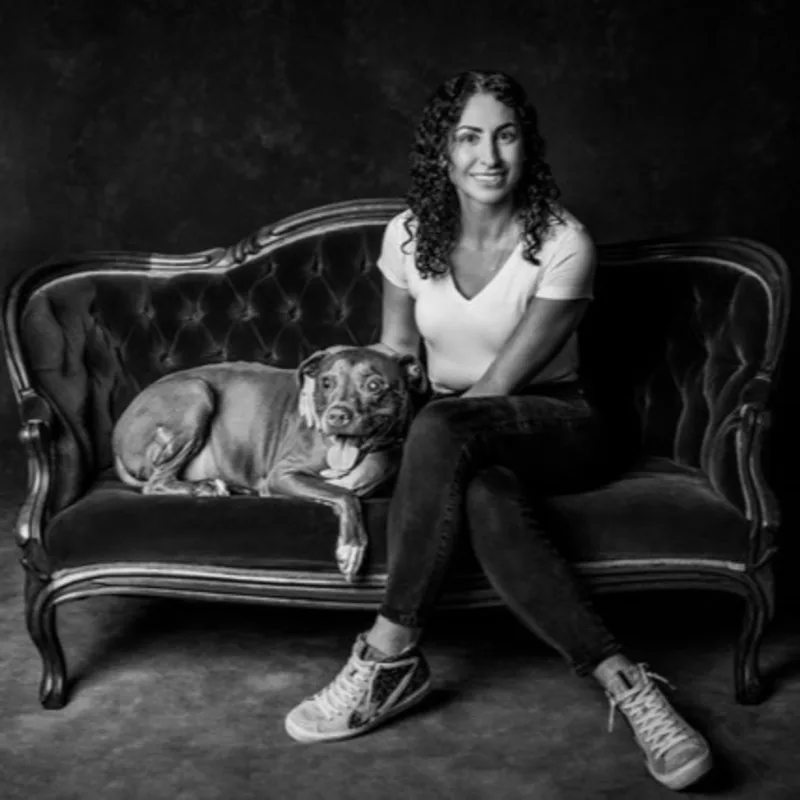 A portrait of Sheena Wilson against a brick wall with a painting of a heart balloon A portrait of Sheena Wilson against a brick wall with a painting of a heart balloon