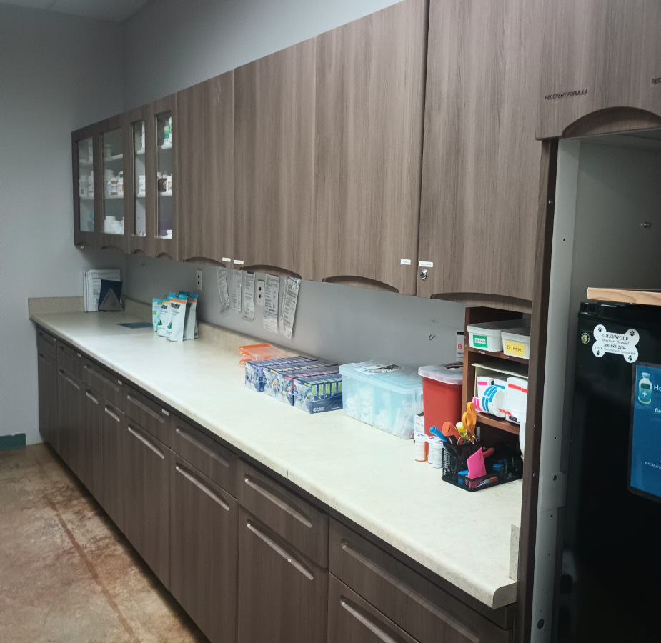 Updated pharmacy area with wooden cabinets and supplies